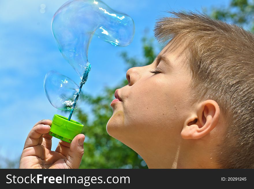 A little boy blows bubbles