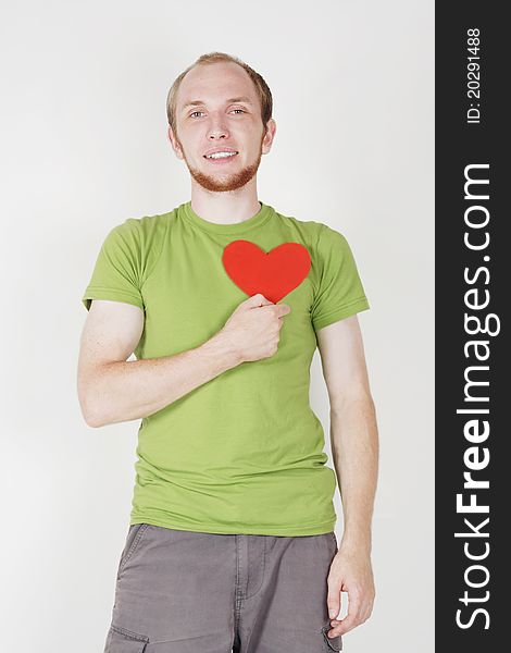 Young man in green shirt holding valentine heart card. Young man in green shirt holding valentine heart card