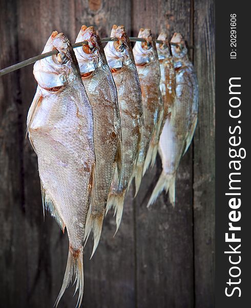 Bunch of salted fish on a wooden wall backdrop