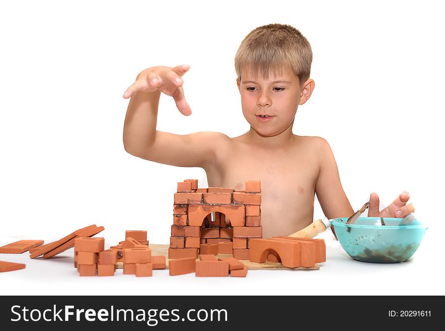 Children's designer. Child build a small house made ​​of bricks
