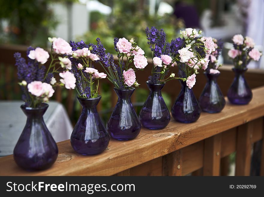 Rose and lavender in purple vases. Rose and lavender in purple vases