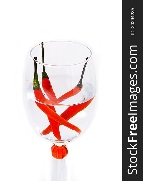 Three red Chillies in a glass of water.