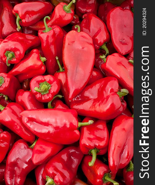Background of many big red peppers, vertical photo