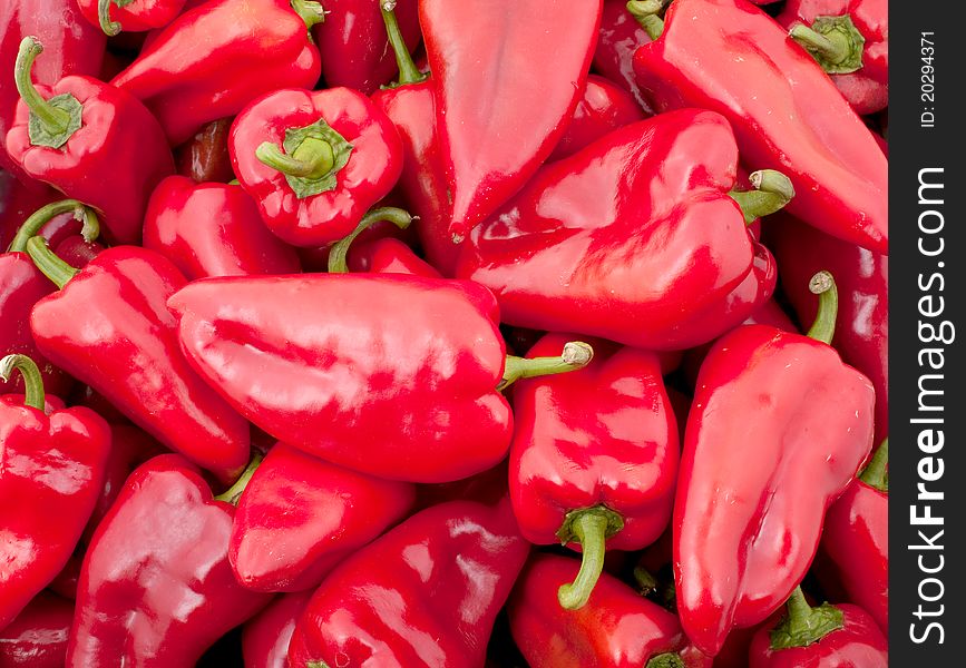 Background of many big red peppers, vertical photo