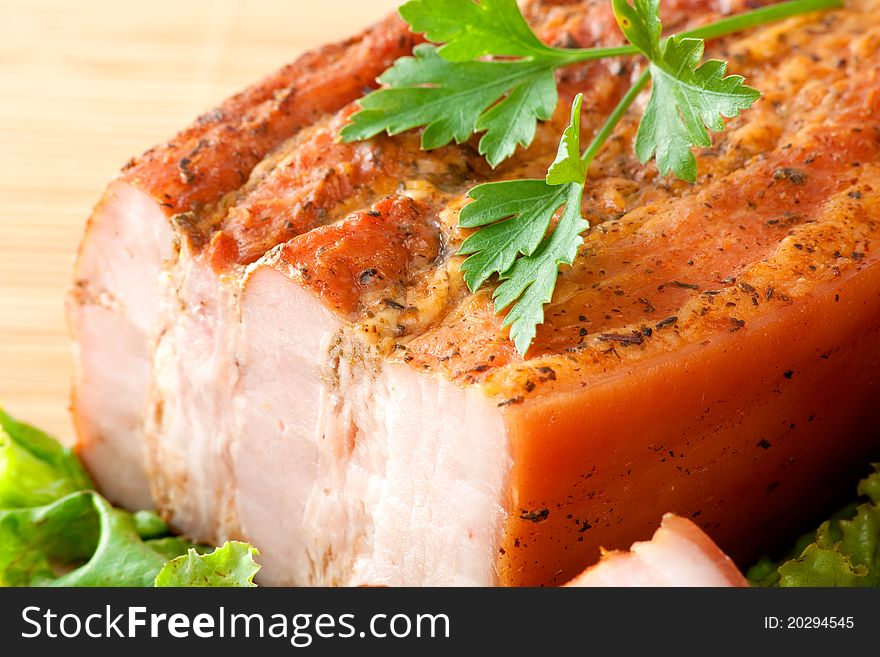 Close up photo of smoked pork arranged on cutting board with parsley