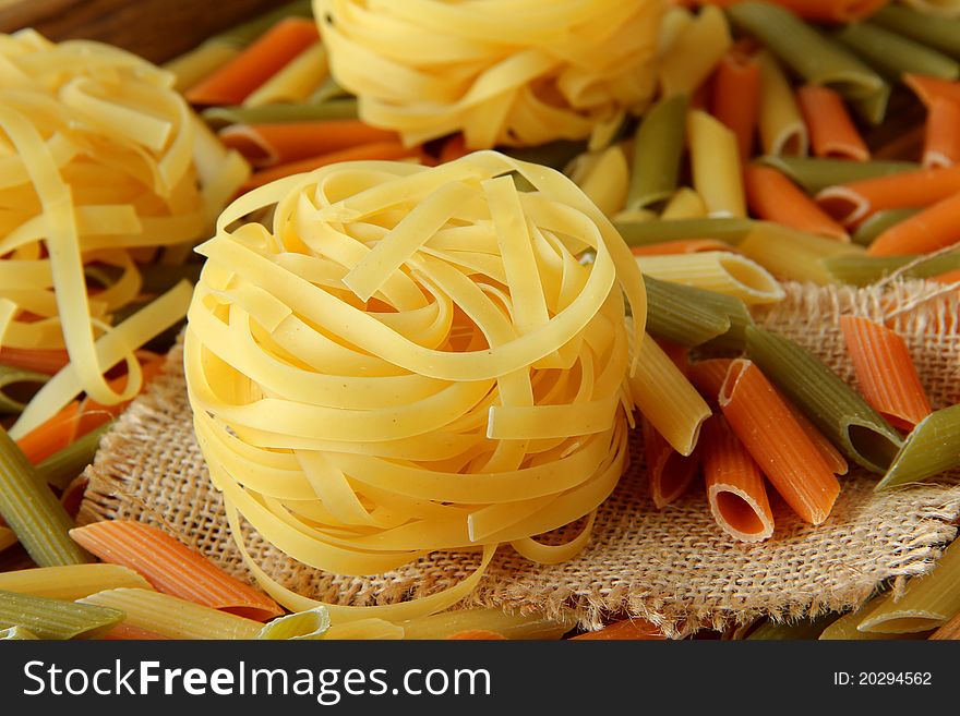 Raw pasta on wood background