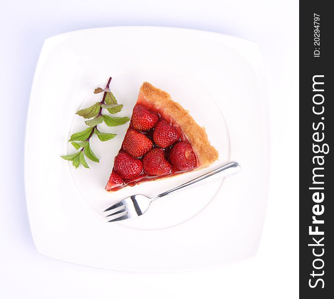 Strawberry Tart on white plate decorated with mint twig