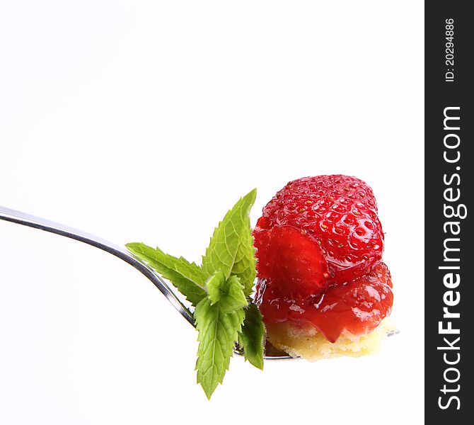 Piece of Strawberry Tart on a fork decorated with mint twig