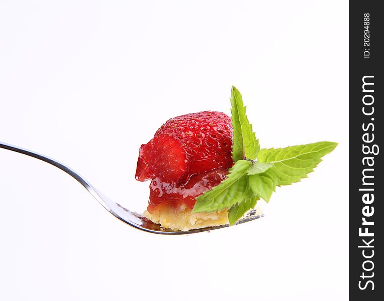 Piece of Strawberry Tart on a fork decorated with mint twig