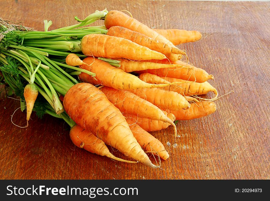 Fresh organic carrots on a wooden background