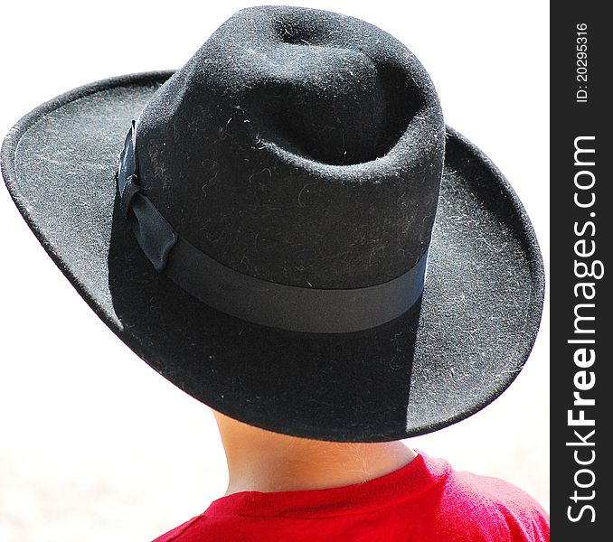 Young cowboy stands watching the local rodeo parade. Young cowboy stands watching the local rodeo parade.