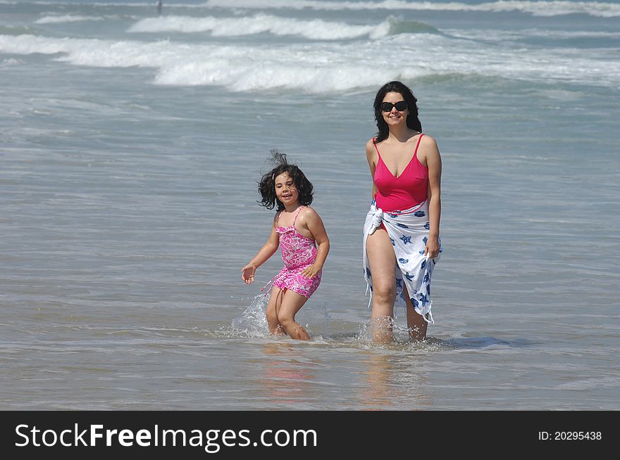 Mother and her baby in the beach near the water