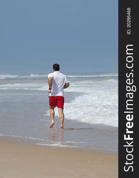 Middle age man running full of energy on the beach