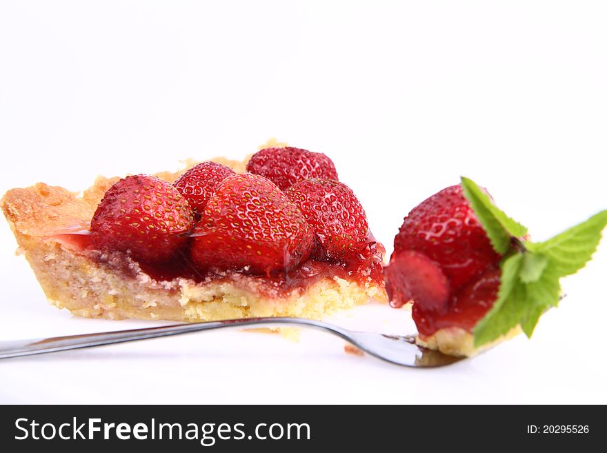 Strawberry Tart portion, a bite on a fork, on a white background