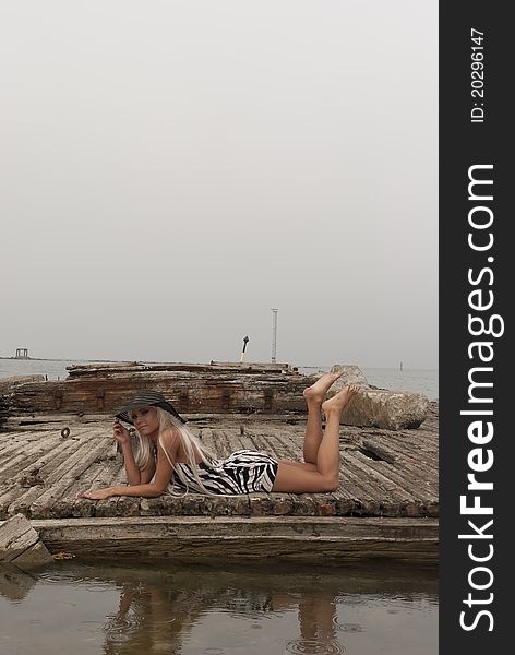 Girl in a hat lying on a broken ship at sea. Girl in a hat lying on a broken ship at sea