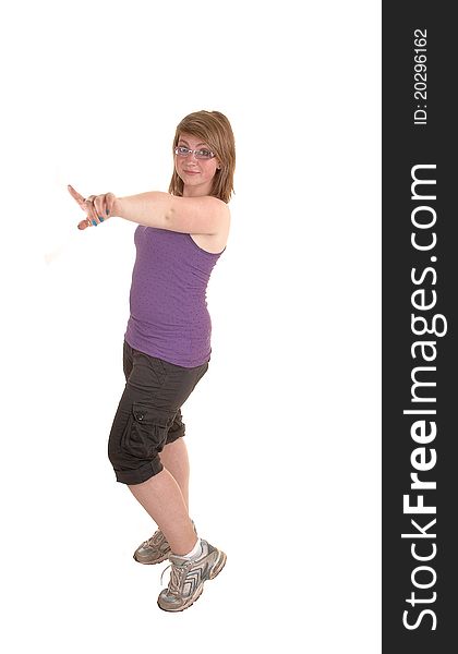 A young teenager in a tank top, knee height pants and running shoes, pointing her finger at the photographer, on white background. A young teenager in a tank top, knee height pants and running shoes, pointing her finger at the photographer, on white background.