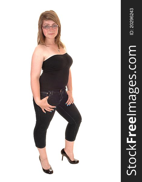 An young teenager standing in the studio in 3/4 jeans and a strapless top and high heels, in the studio with glasses for white background. An young teenager standing in the studio in 3/4 jeans and a strapless top and high heels, in the studio with glasses for white background.