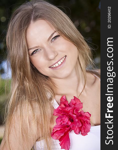 Portrait of a beauty blonde girl with red flower