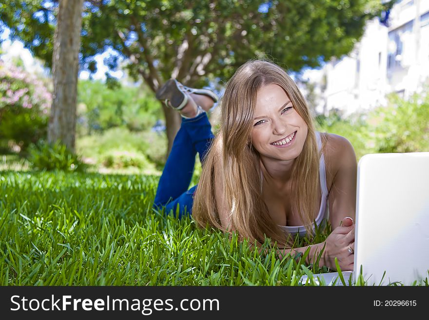 Beauty blonde girl studying outdoor with laptop and posing for shot. Beauty blonde girl studying outdoor with laptop and posing for shot