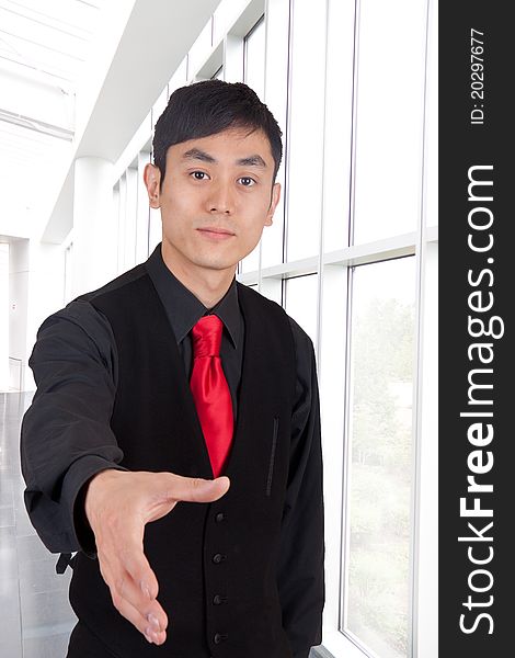 Hip young Asian man with hand out at the airport. Hip young Asian man with hand out at the airport