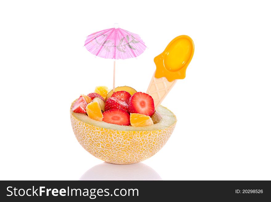 A fresh fruit salad in a hollowed melon nicely decorated and isolated over a white background
