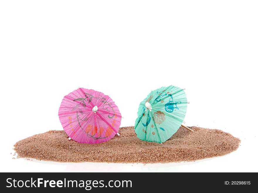 Two colorful parasols on the beach isolated over white