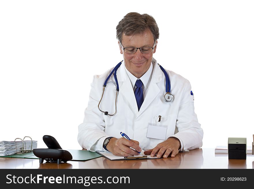 Trustful aged doctor writes down prescription smiling. Isolated on white background.