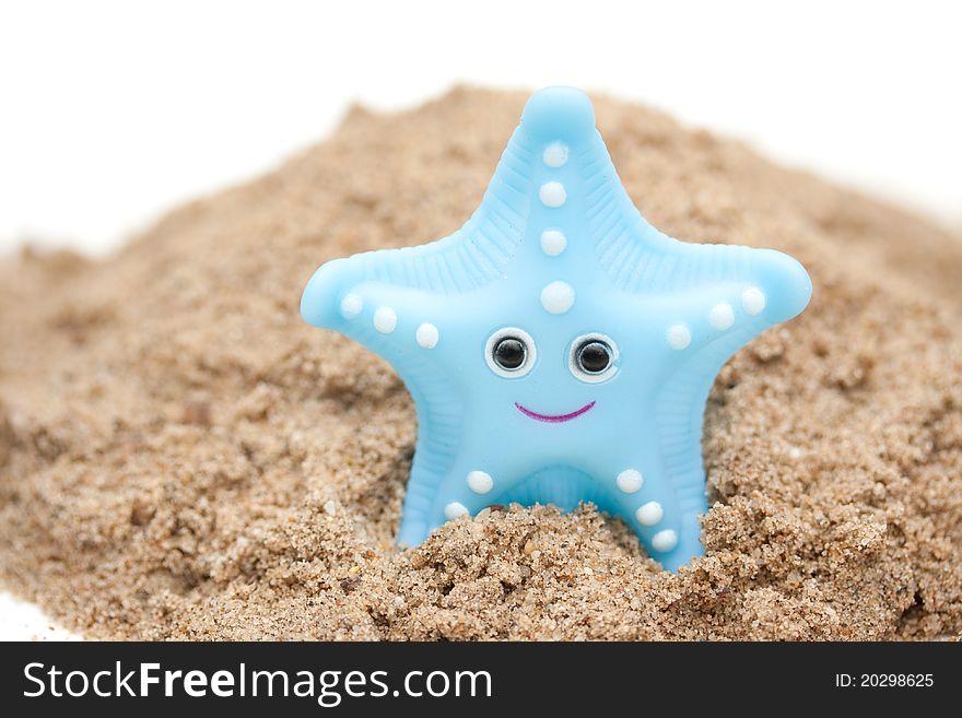 A plastic starfish on the beach isolated over white