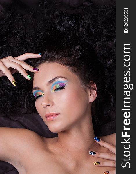 Woman with professional colourful make-up and sparkling manicure isolated on black. Woman with professional colourful make-up and sparkling manicure isolated on black
