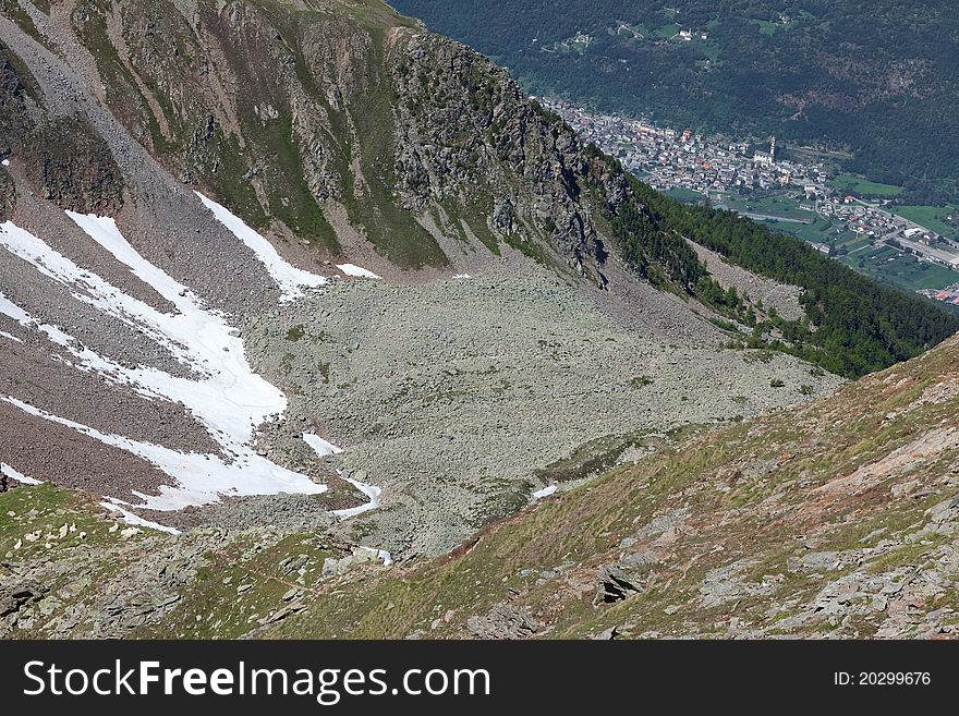 Peak over the village. Varadega Peak at 2634 meters on the sea-level during summer. Brixia province, Lombardy region, Italy. Under the peak a small village