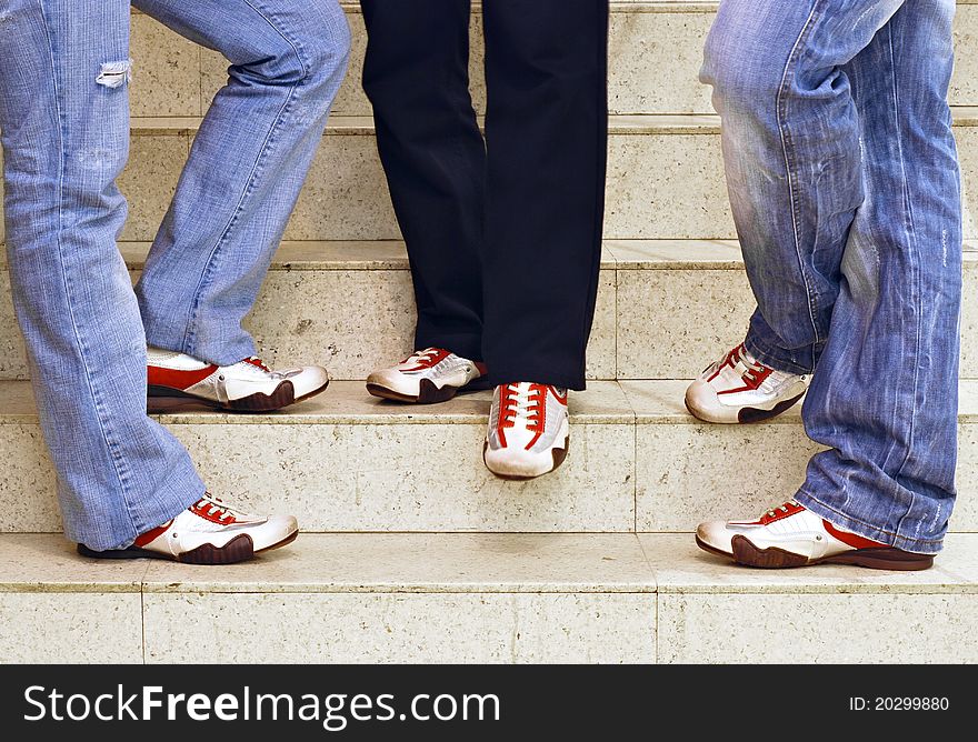 Menâ€™s feet in sneakers standing on the stairs. Menâ€™s feet in sneakers standing on the stairs