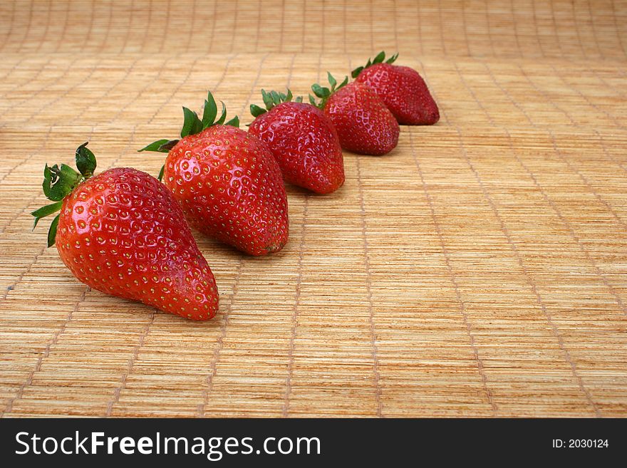 Big red strawberries on a doormat. Big red strawberries on a doormat