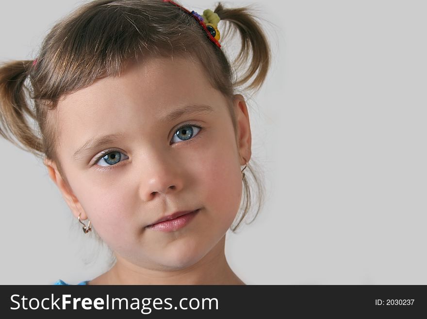 Little girl with blue eye, gray background