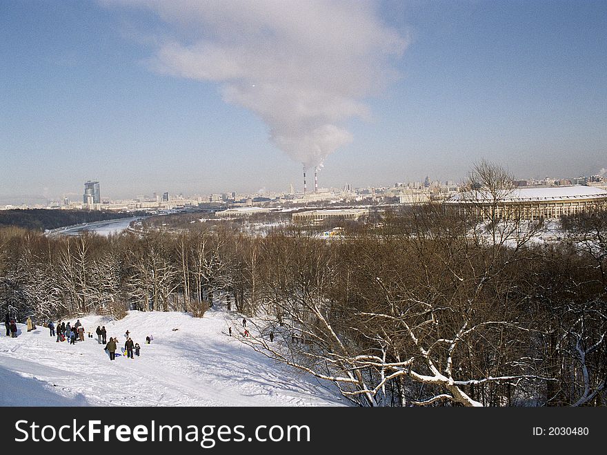 Beautiful view on winter moscow in background big air polution in front children on hill. Beautiful view on winter moscow in background big air polution in front children on hill