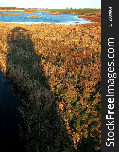 High tower made of shadow on the lake