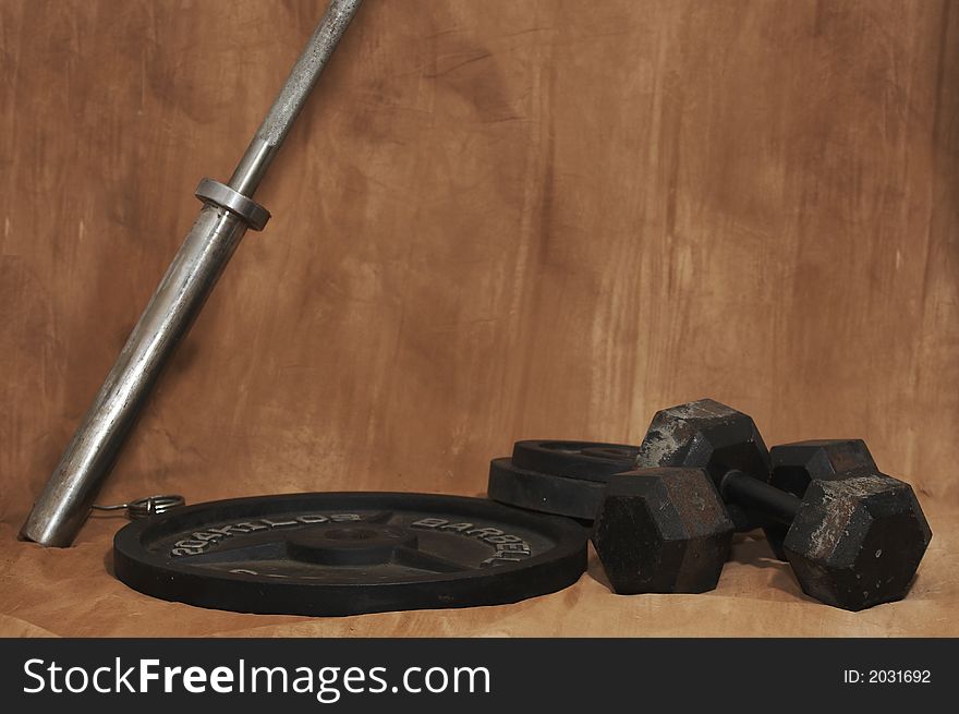Free weights on ground with brown background. Free weights on ground with brown background