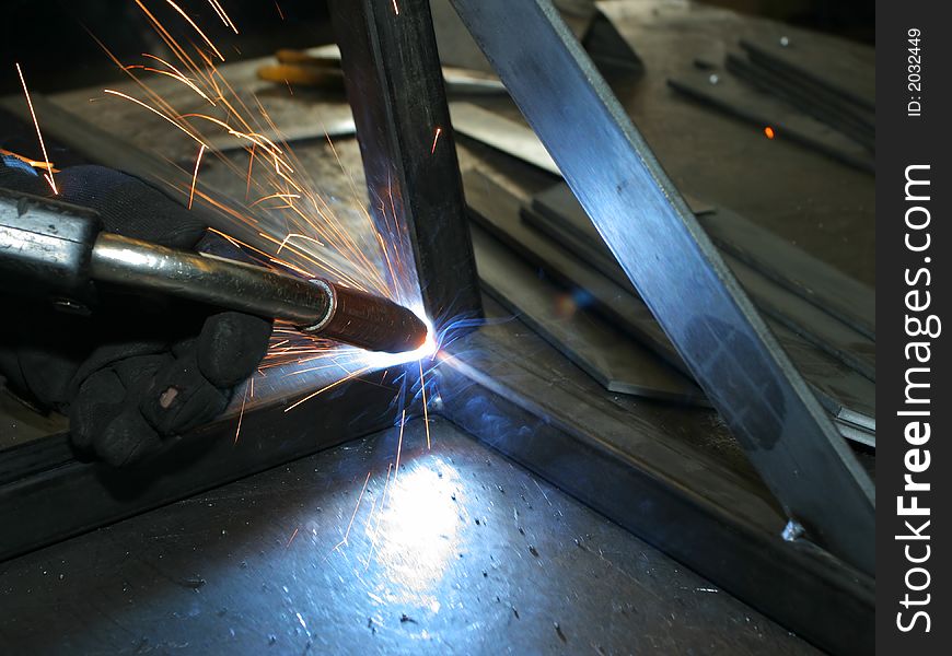 Welder working at metal frame; making sparks. Welder working at metal frame; making sparks