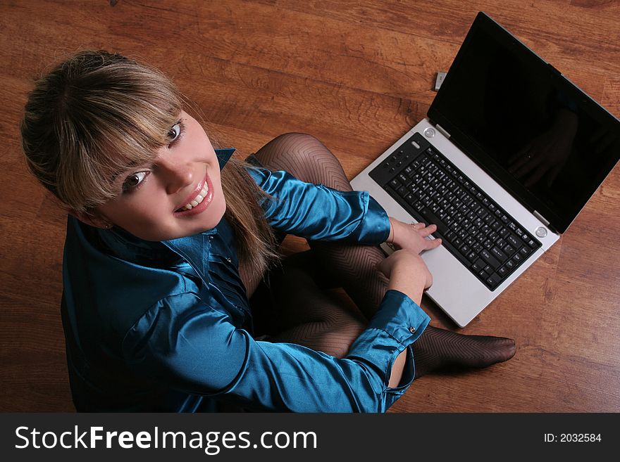 Smiling beautiful girl sitting on floor with laptop. Smiling beautiful girl sitting on floor with laptop.