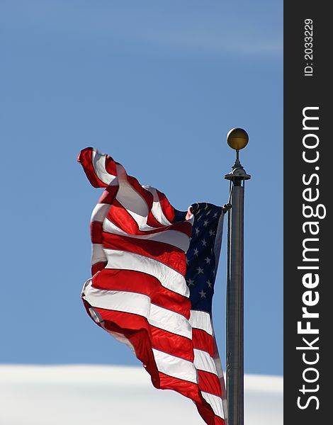 American Flag waving against a blue sky background. American Flag waving against a blue sky background