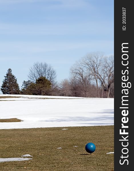 Men's tee box on a winter's day, snow covers the fairway.