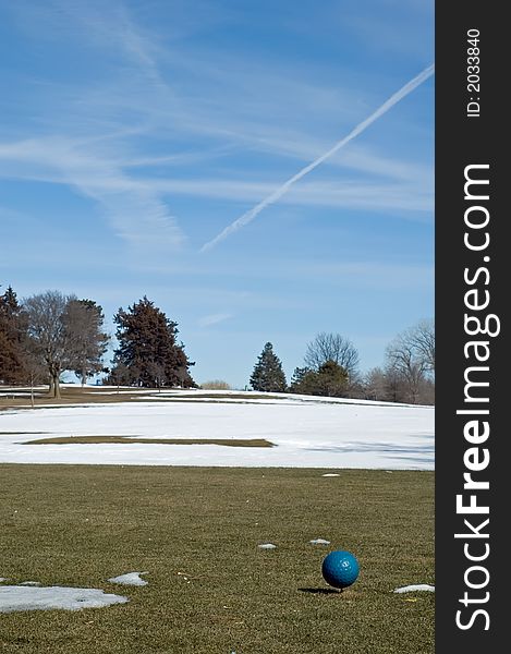 Men's tee box on a winter's day, snow covers the fairway.