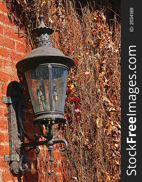 Old rusty lantern on the colorful brick wall