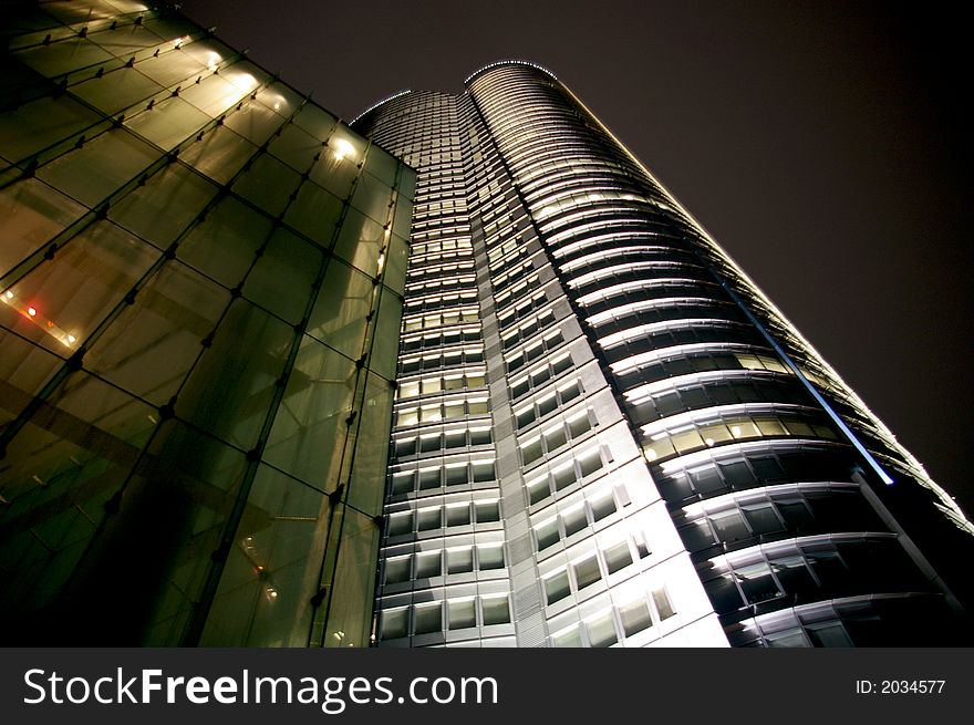 A photograph of an office tower taken at night. A photograph of an office tower taken at night.