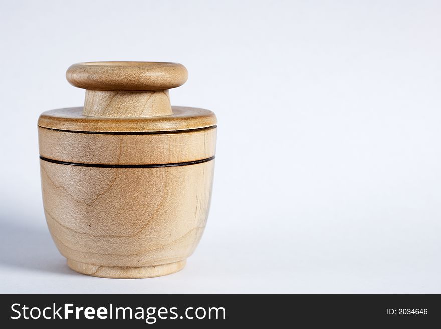 Close-up of a wooden jar with a black ring on white background