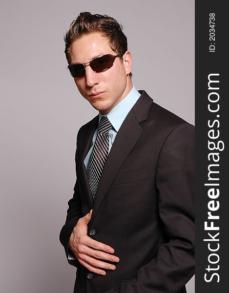 A businessman is posing against gray background. A businessman is posing against gray background