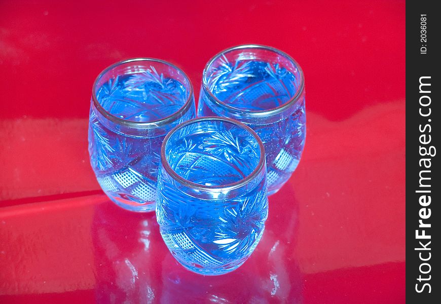 Several blue glasses on red background. Several blue glasses on red background