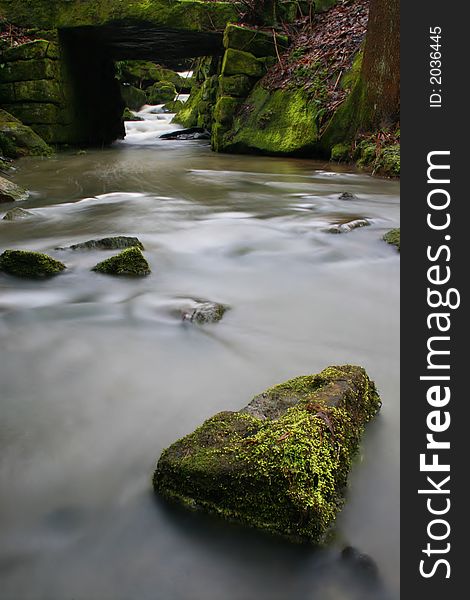 Creek with the bridge and some stones