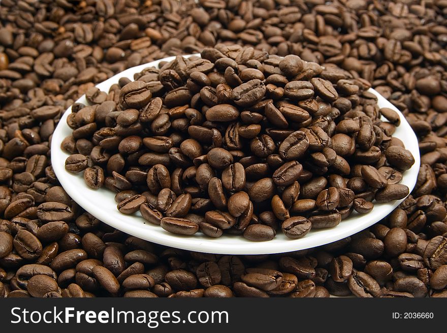 Saucer with roasted coffee beans. Saucer with roasted coffee beans