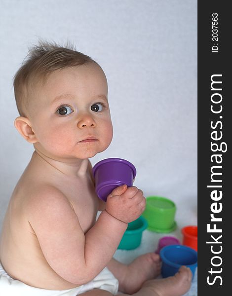 Image of adorable baby playing with stacking cups. Image of adorable baby playing with stacking cups