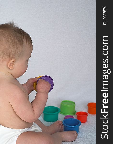 Image of adorable baby playing with stacking cups. Image of adorable baby playing with stacking cups